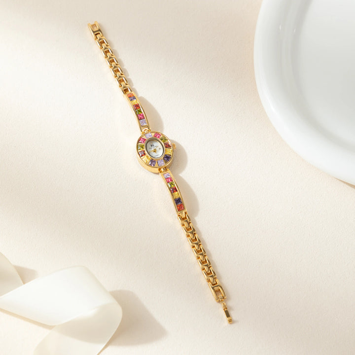 Amelie – Goldene Uhr mit kristallinem Rahmen.