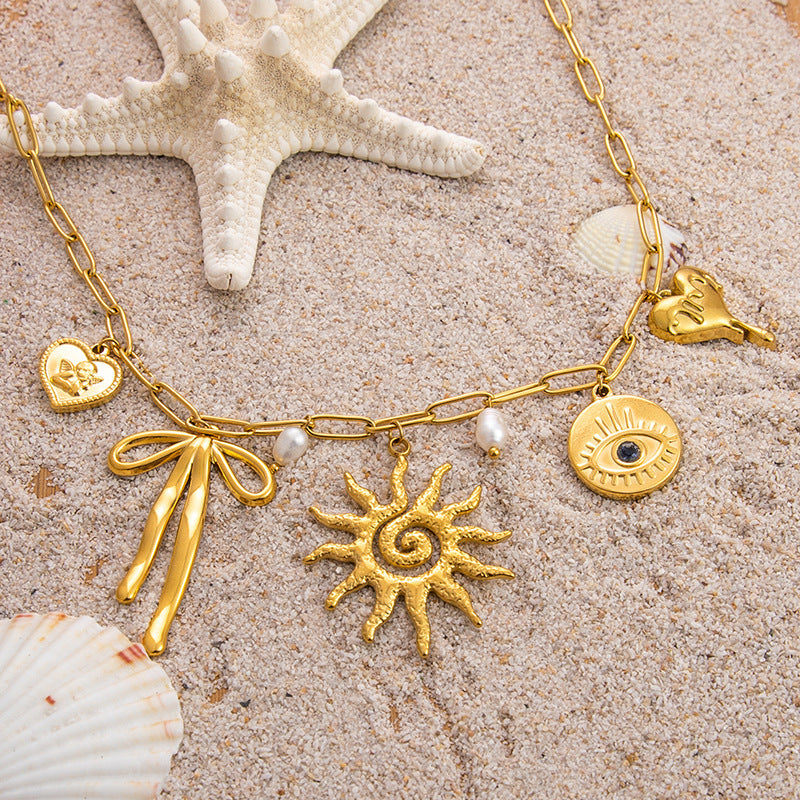 Emilia – Zarter goldener Halsreifen mit kleinen Anhängern.